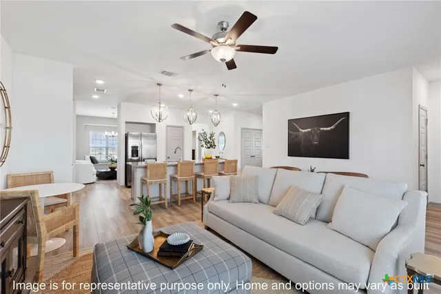 a living room with furniture kitchen view and a chandelier