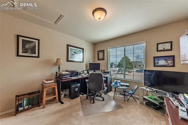a view of a livingroom with workspace and a window