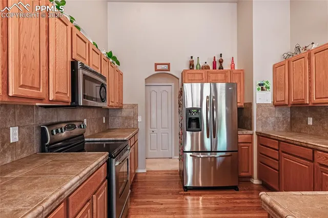 a kitchen with stainless steel appliances granite countertop a refrigerator a stove a sink and a microwave