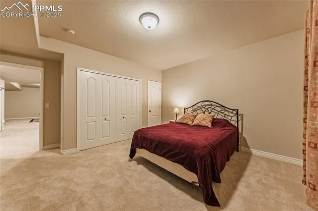 a spacious bedroom with a bed and a lamp
