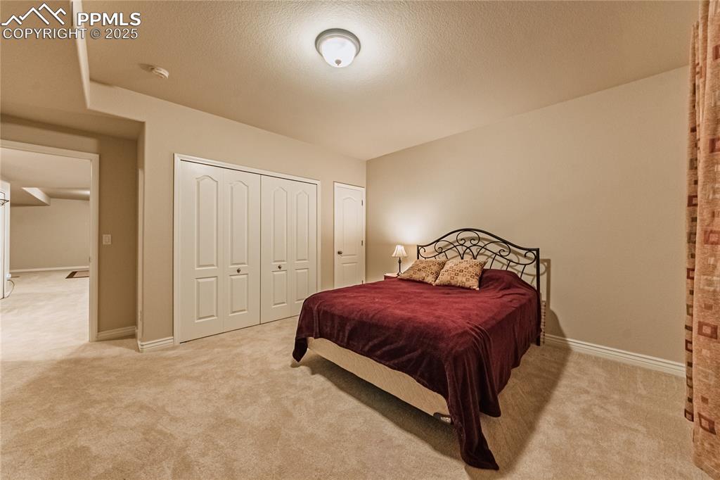 11171 Allendale Drive Peyton, CO 80831 - Photo 35 of 50 a spacious bedroom with a bed and a lamp