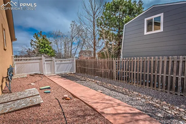 a view of backyard with wooden fence