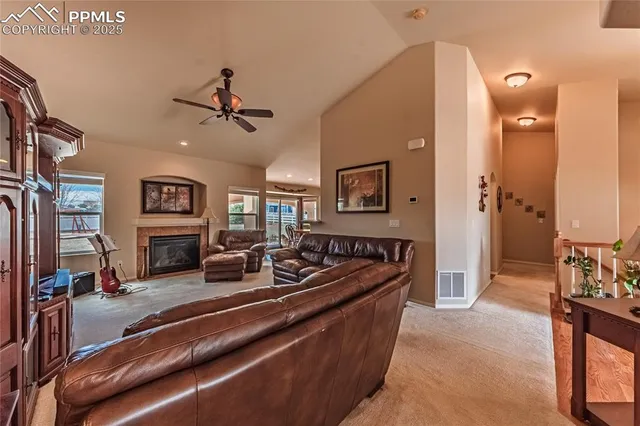 a living room with furniture a flat screen tv and a chandelier