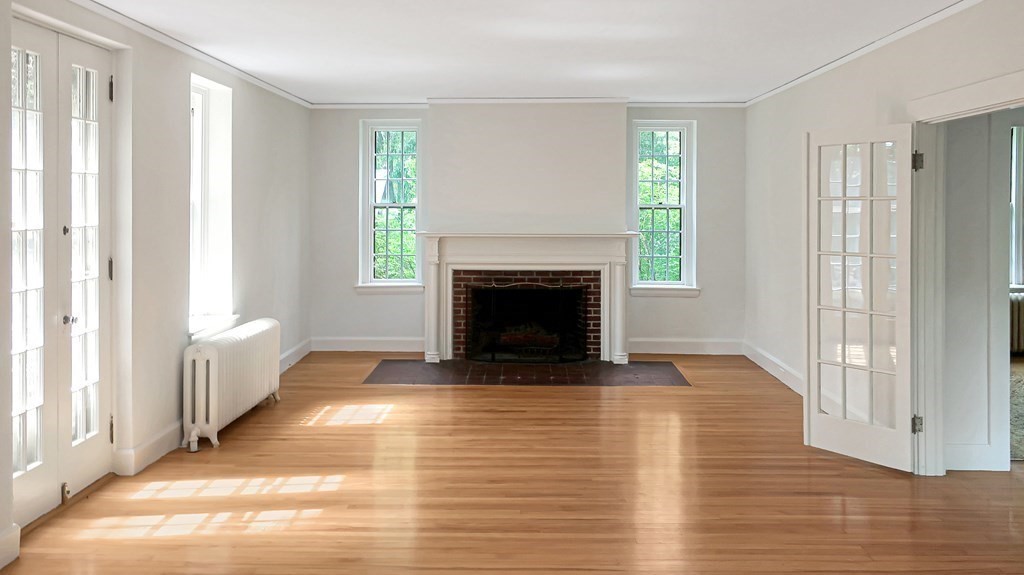 39 Locust Avenue Lexington, MA 02421 - Photo 4 of 32 a view of an empty room with wooden floor fireplace and a window