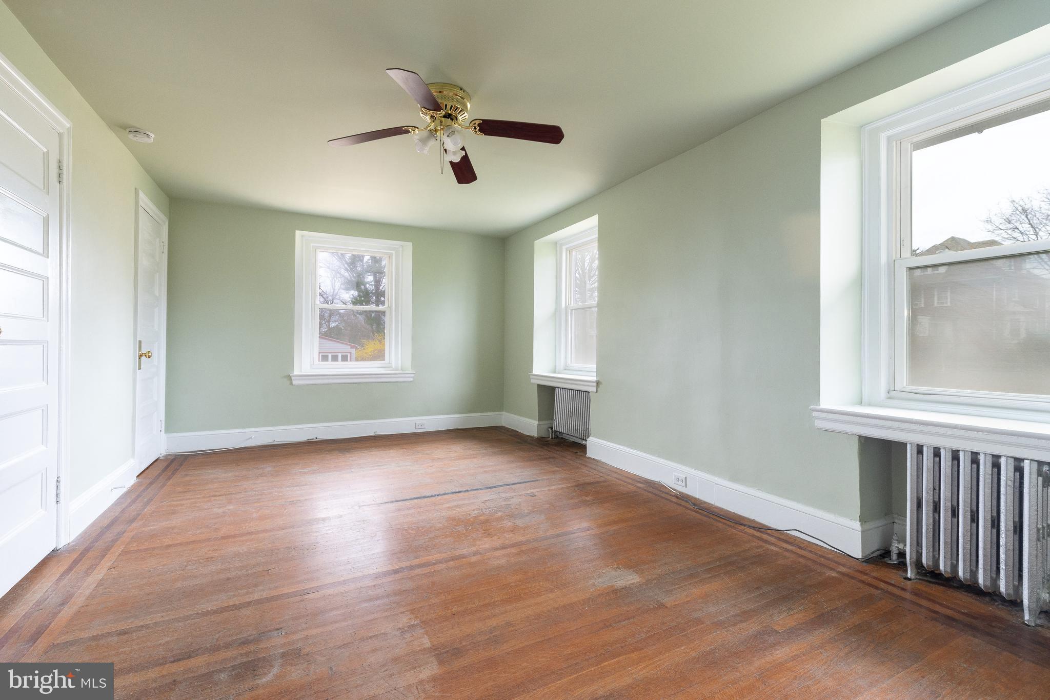 112 East Township Line Road Havertown, PA 19083 - Photo 15 of 40 an empty room with wooden floor chandelier fan and windows