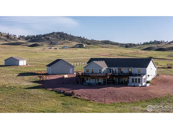 a aerial view of a house with big yard and large mountain view