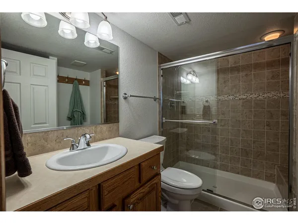 a bathroom with a sink toilet a mirror and shower