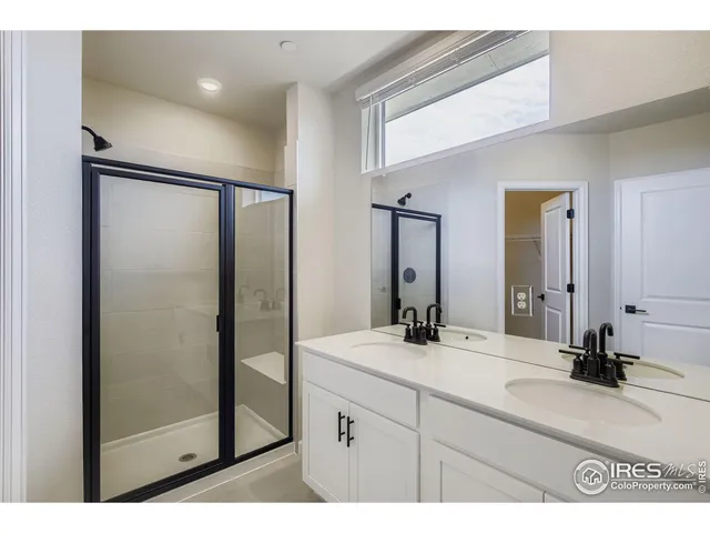 a bathroom with a double vanity sink mirror and shower