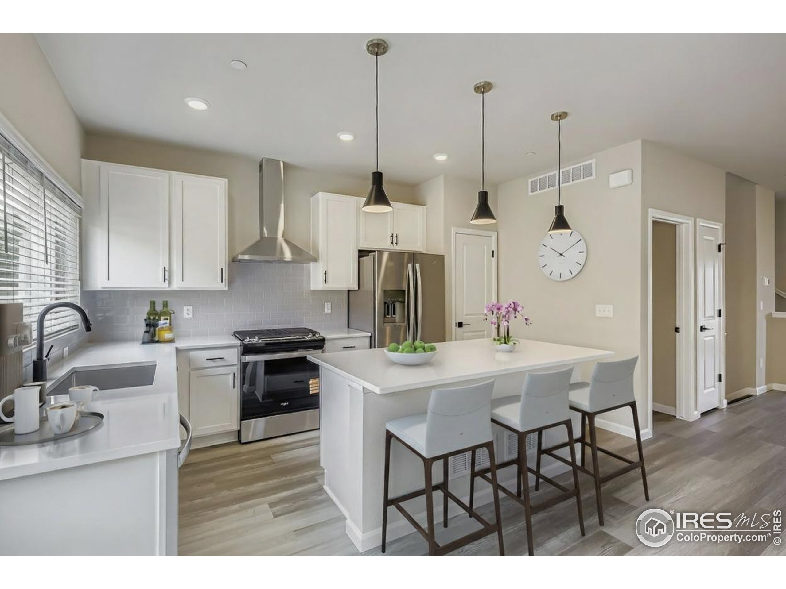 945 Abbott Lane, Unit 4 Fort Collins, CO 80524 - Photo 5 of 20 a kitchen with stainless steel appliances kitchen island granite countertop a sink a stove a refrigerator and white cabinets