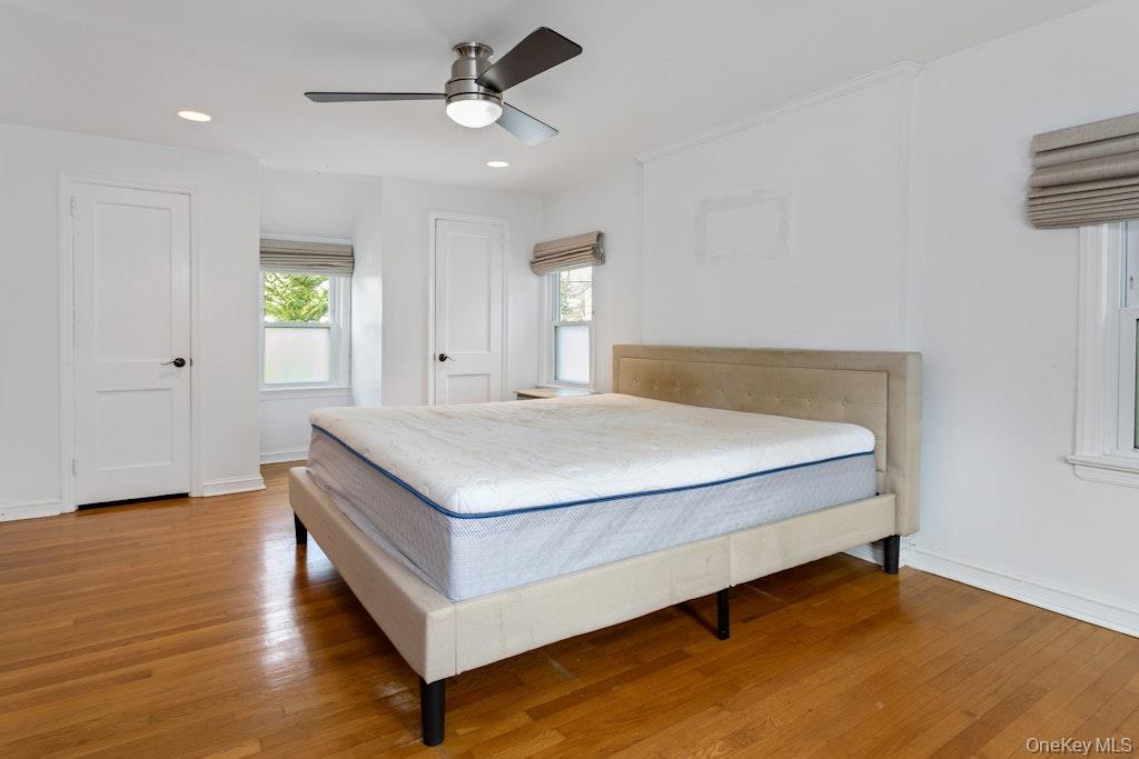 155 White Road Scarsdale, NY 10583 - Photo 10 of 16 Bedroom with wood flooring, a ceiling fan, two closets, and recessed lighting.