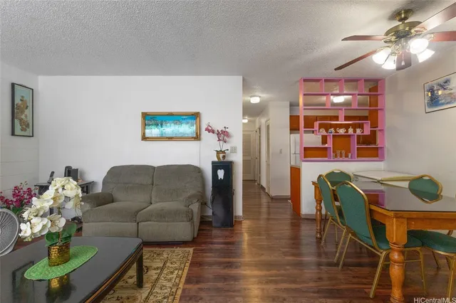 a living room with furniture a dining table with wooden floor and a chandelier