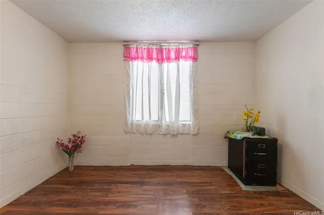 a view of a room with wooden floor and a window