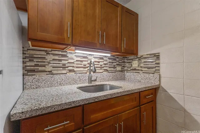 a kitchen with granite countertop a sink and cabinets