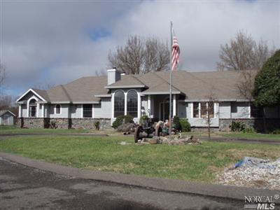 a front view of a house with a garden and trees