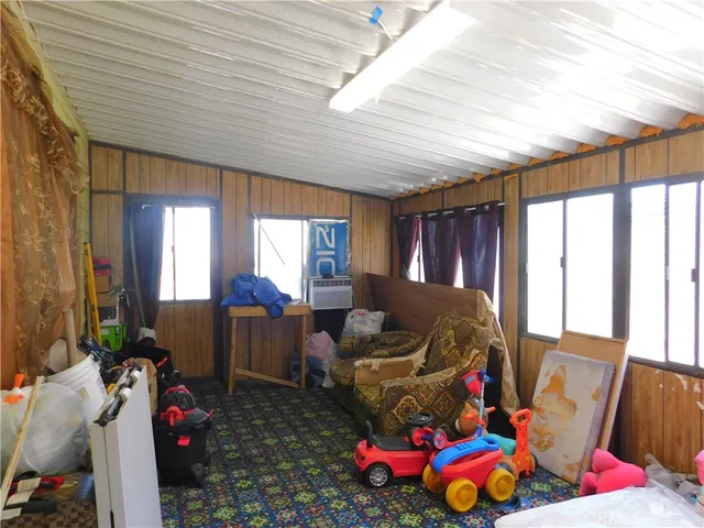 a living room with furniture a couch and dresser with windows