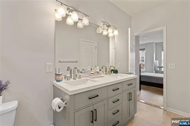 a bathroom with a double vanity sink mirror and toilet