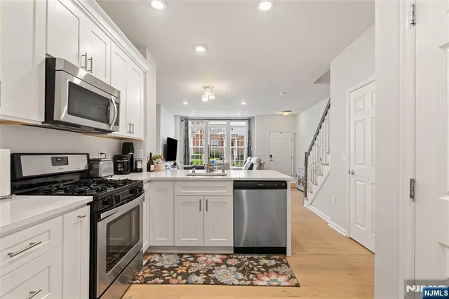 a kitchen with stainless steel appliances granite countertop a stove a sink and a microwave