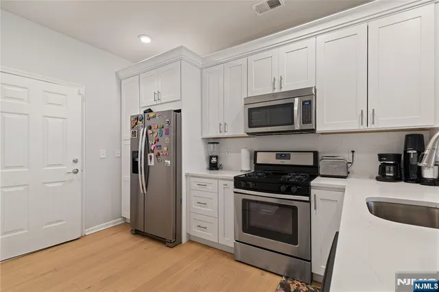 a kitchen with refrigerator a microwave and cabinets