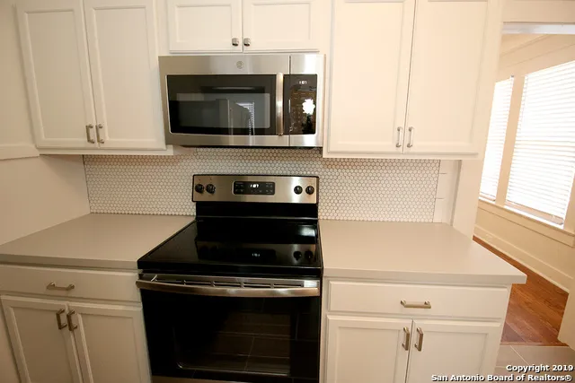 a kitchen with stainless steel appliances a stove a microwave and cabinets