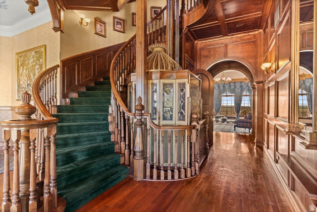 5615 East Eight Mile Gap Road Kanab, UT 84741 - Photo 24 of 81 Stairs with crown molding, a chandelier, hardwood / wood-style floors, a decorative wall, and arched walkways