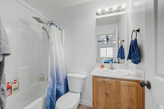 1692 South Windemere Road Santaquin, UT 84655 - Photo 9 of 23 Bathroom featuring a shower/tub combination with a wall-mounted showerhead, a single vanity with a laminate countertop, and a wood-finish cabinet