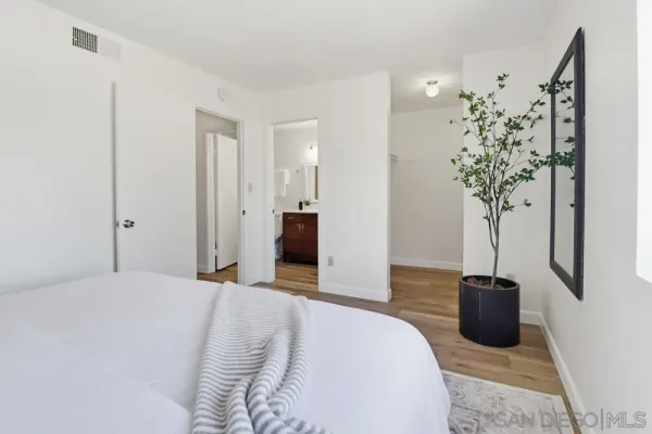 a bedroom with a bed and a potted plant