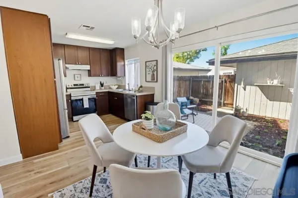 a view of a dining room with furniture a chandelier and wooden floor