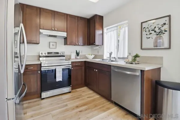 a kitchen with stainless steel appliances granite countertop a stove a sink dishwasher and a refrigerator