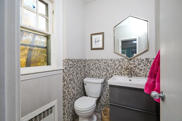 a bathroom with a toilet a sink and a mirror