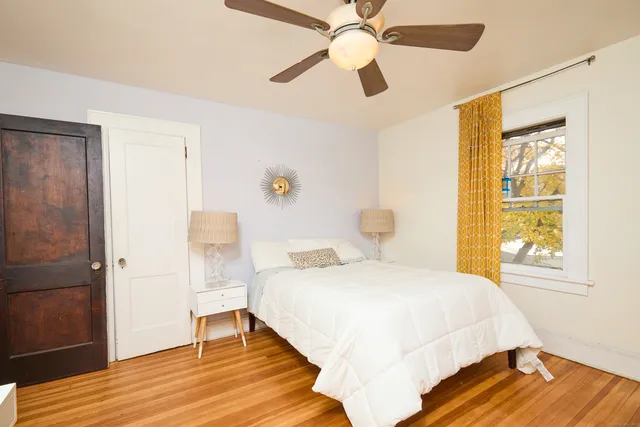 a bedroom with a bed and wooden floor
