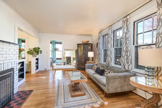 a living room with fireplace furniture and a rug