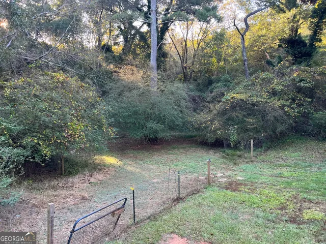 a view of a backyard with table and chairs and barbeque grill