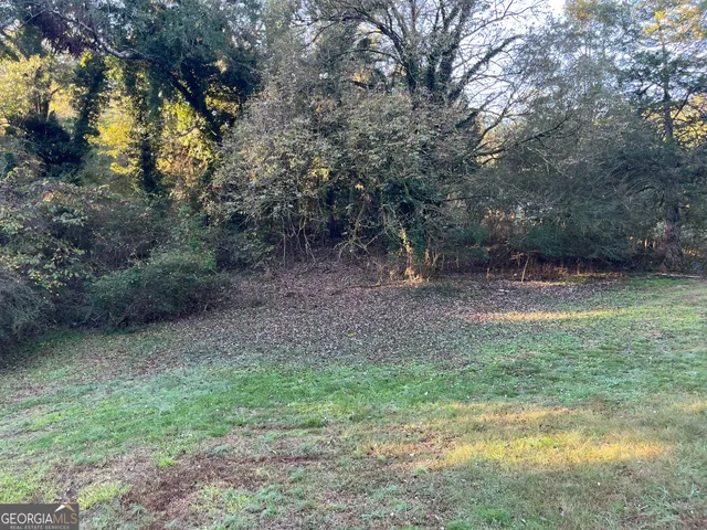 a view of a backyard with table and chairs and barbeque grill