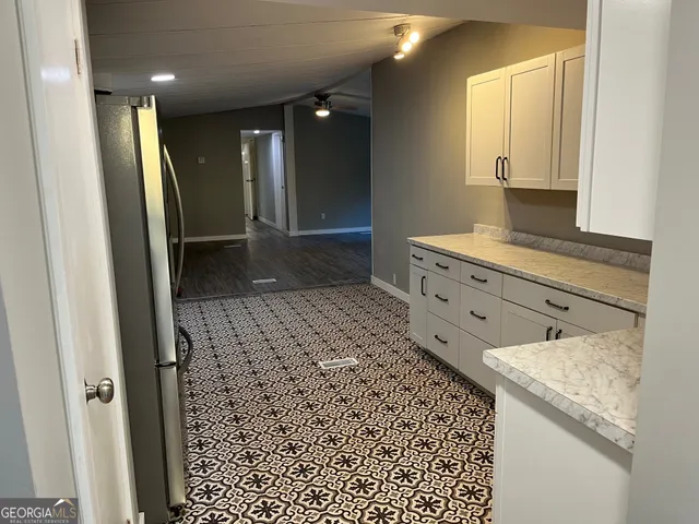 a view of an empty room with glass door and wooden floor