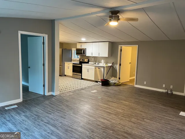 a view of a livingroom with wooden floor and windows