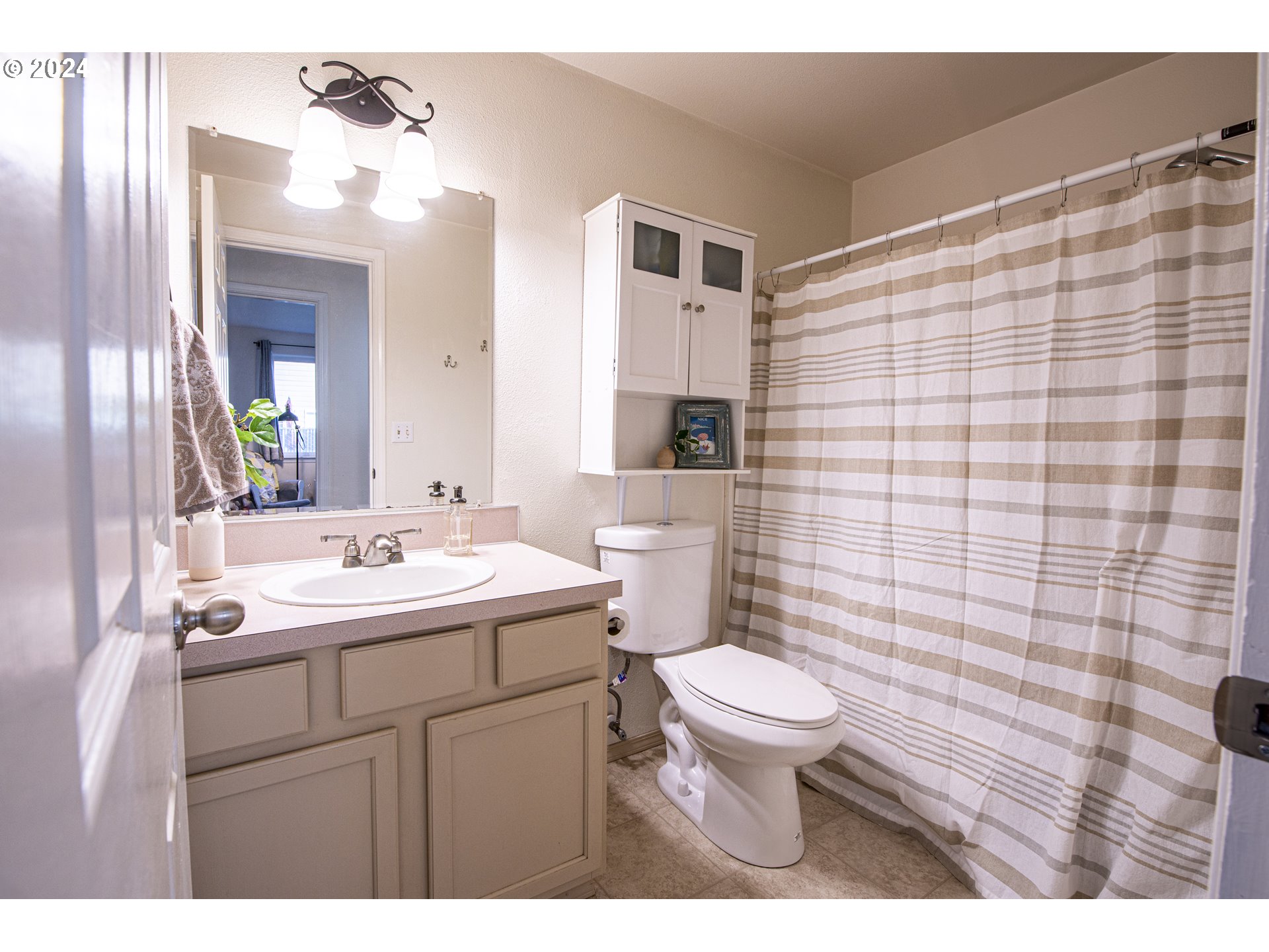 4128 Forsythia Street Springfield, OR 97478 - Photo 16 of 27 a bathroom with a sink a toilet and shower curtain