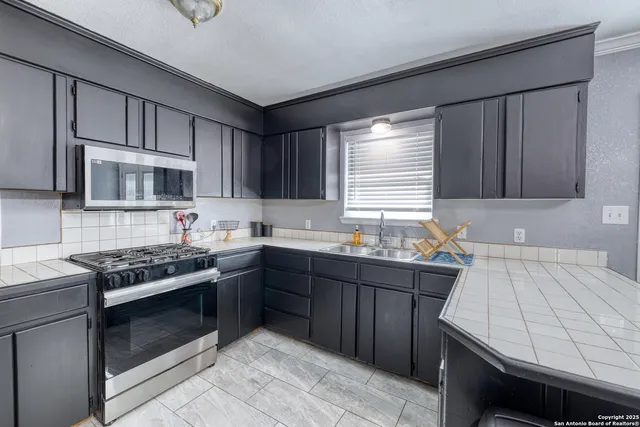 a kitchen with stainless steel appliances a stove sink and cabinets