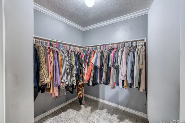 a view of walk in closet with clothes and shoes