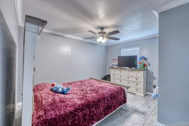 a bedroom with a large bed and a flat tv screen