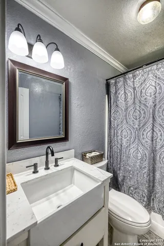 a bathroom with a toilet sink and mirror