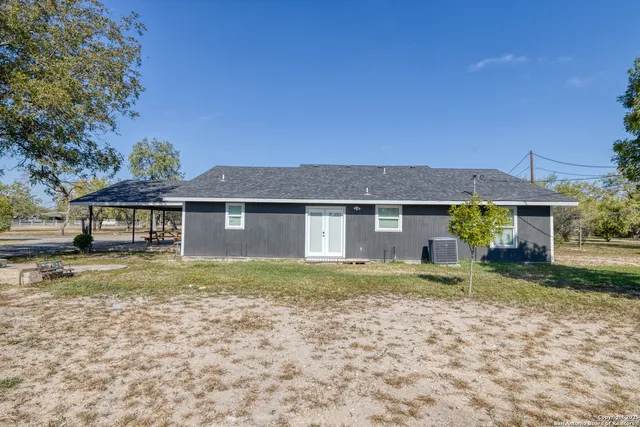 a view of a yard in front of a house with large tree