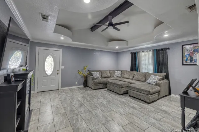 a living room with furniture a large window and wooden floor