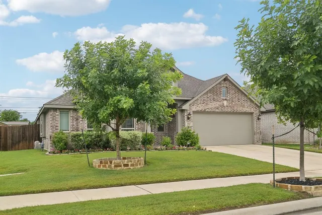 a front view of a house with a garden and yard