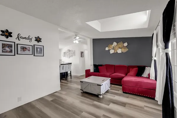 a living room with furniture a flat screen tv and kitchen view