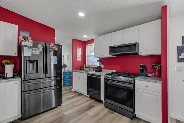 a kitchen with stainless steel appliances a stove microwave and refrigerator