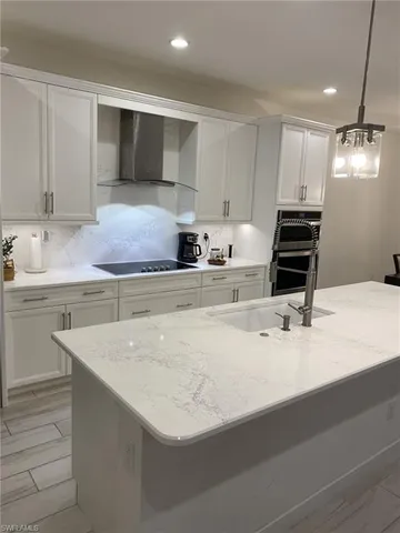 a kitchen with stainless steel appliances a sink and white cabinets