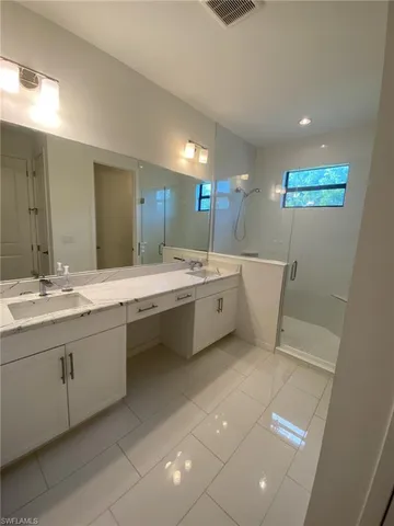 a bathroom with a double vanity sink a mirror and a bathtub