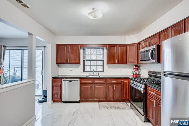 a kitchen with stainless steel appliances granite countertop a refrigerator sink and cabinets