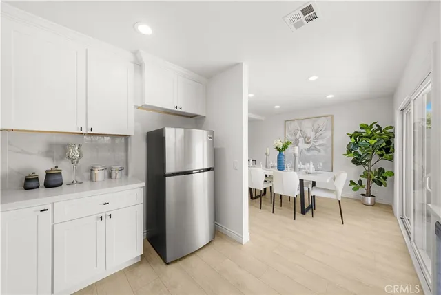a kitchen with refrigerator and cabinets