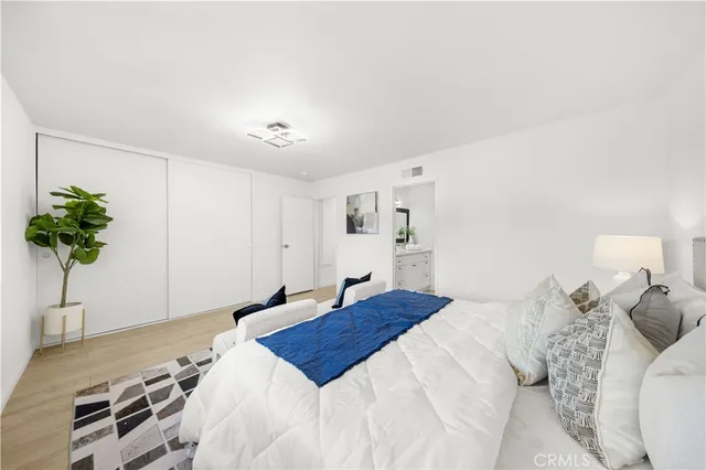 a bedroom with a bed and a potted plant